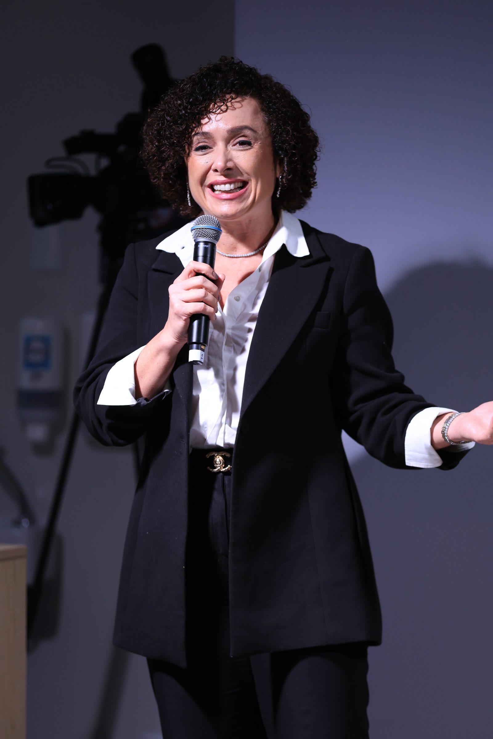 Dra. Patrícia Bretz palestrando ao microfone para uma plateia de médicos
